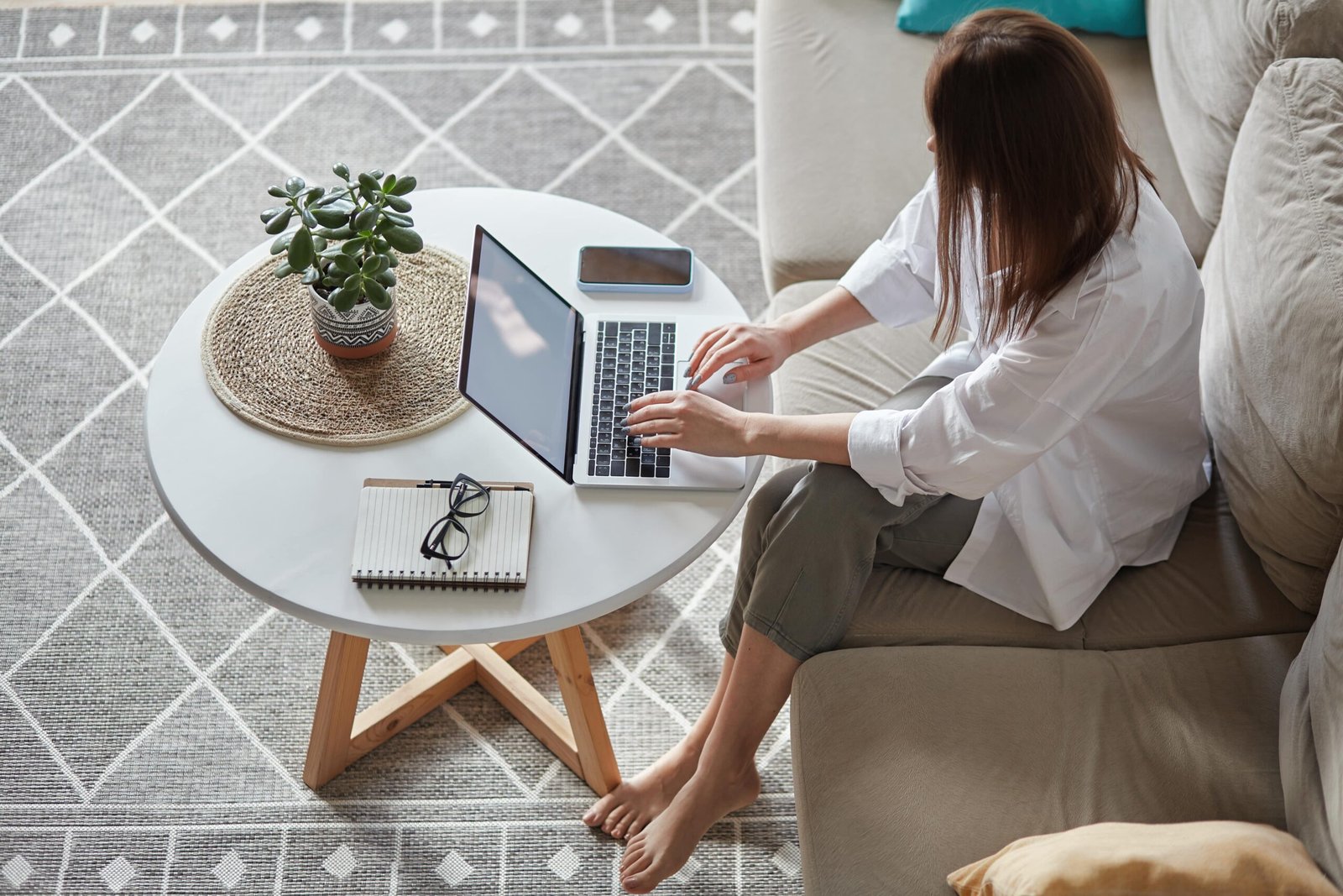 mockup white screen laptop woman using computer sitting sofa home top view min